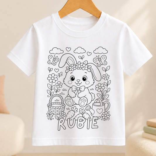 Personalised bunny rabbit colour-in kids t-shirt with a black-and-white line-art bunny wearing a flower crown among daisies, butterflies and a carrot, with the child's name printed beneath in bubble letters