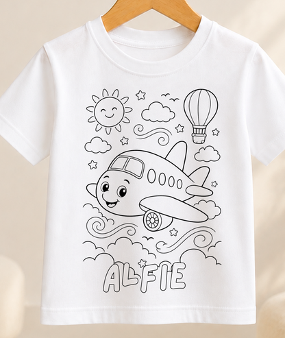 Colour-in kids t-shirt with a black-and-white line art airplane flying through fluffy clouds, personalised with a name