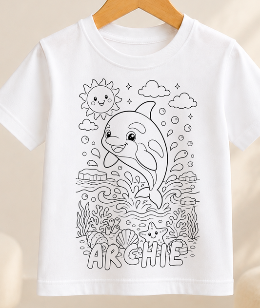 Colour-in kids t-shirt with a black-and-white line art orca leaping through ocean waves, personalised with a name