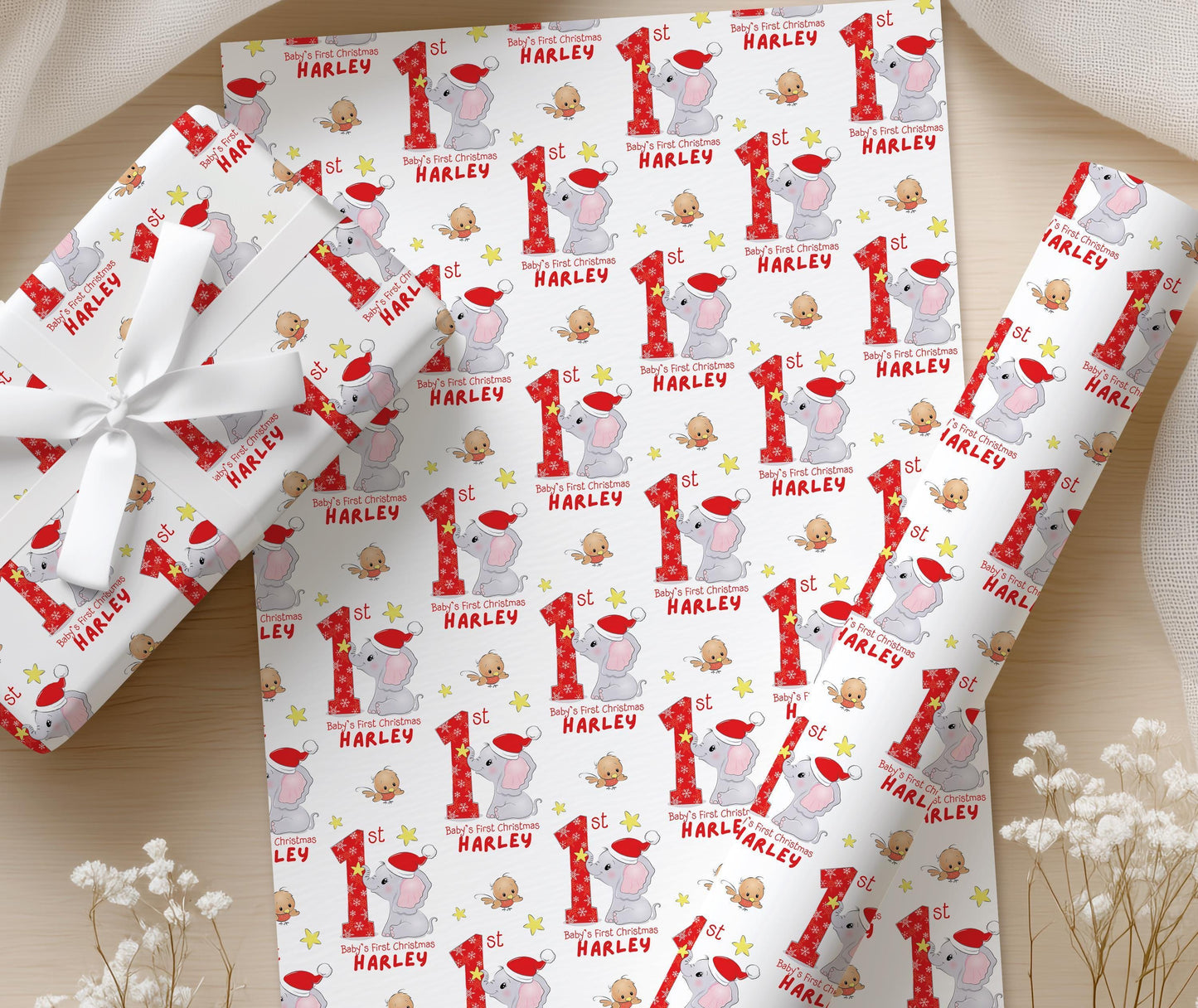 Personalised Baby's First Christmas wrapping paper laid flat showing the repeating elephant, star and custom name pattern.