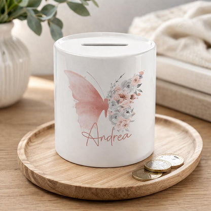 Personalised ceramic money box styled against a cream knit throw with blush pink gift boxes
