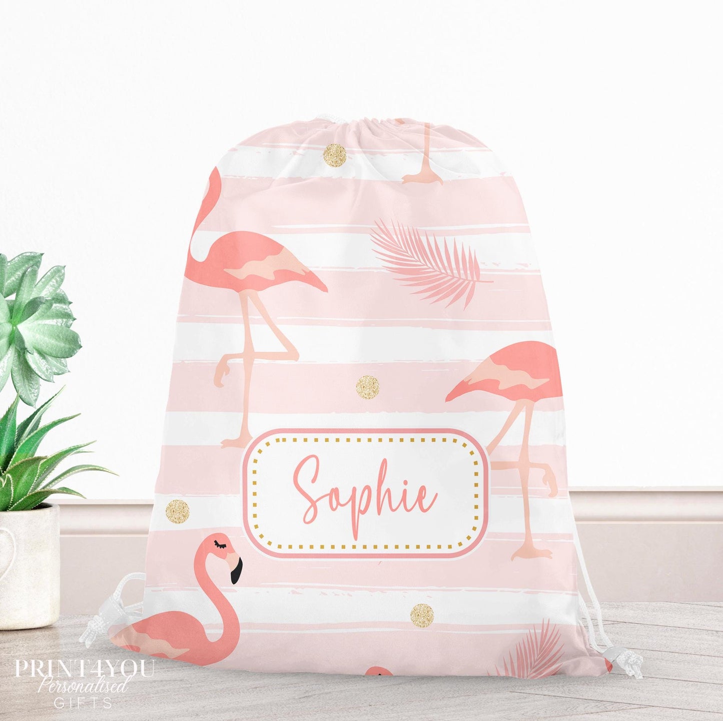 Pink drawstring PE bag printed with a flamingo, palm leaf and gold dot design, personalised with a child's name across the front