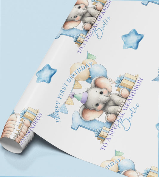 Roll of personalised first birthday wrapping paper featuring a repeating baby elephant, blue number one and balloon design.