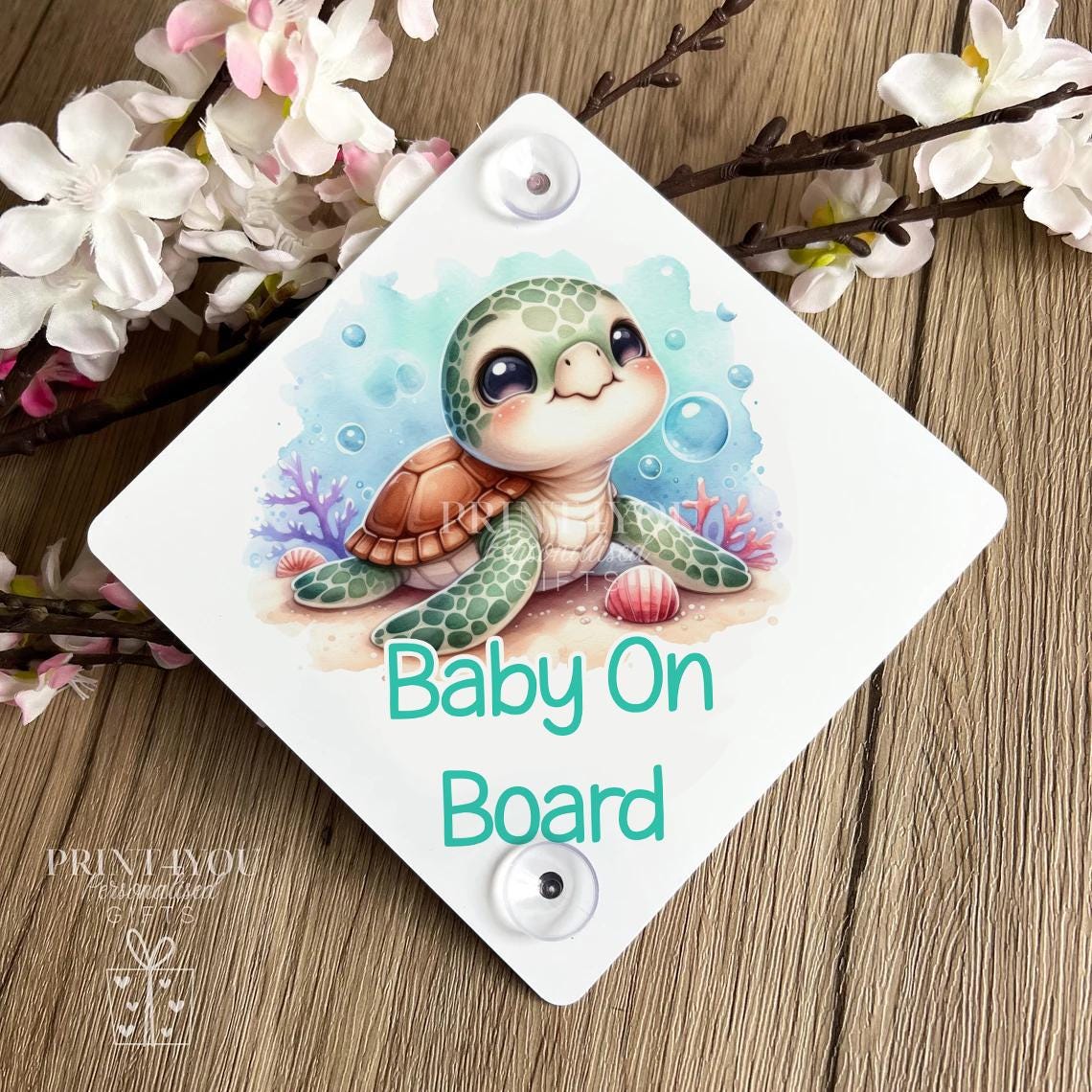 Baby on board car sign with turtle illustration, shown on a plain background