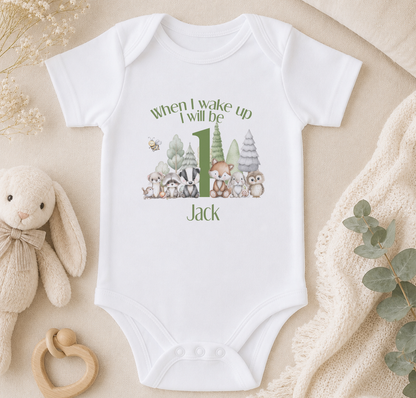 A white onesie with a graphic of woodland animals and the text "When I wake up I will be Jack" printed on it, along with a rabbit and a bumble bee.