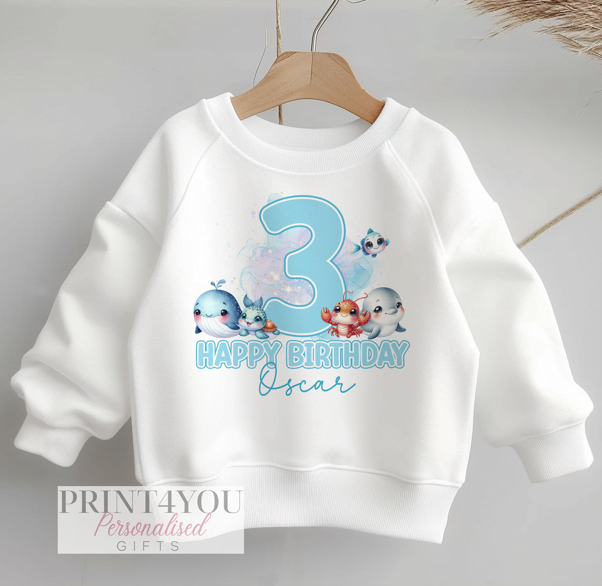 Personalised white sweatshirt for children with blue under the sea animals design, customised with name and birthday number