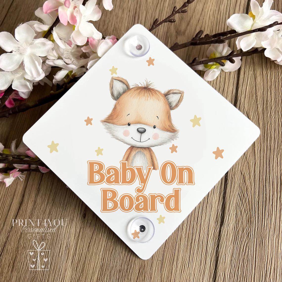 Baby on board car sign with fox design attached to a car window