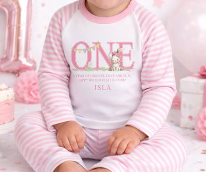 Personalised first birthday pyjamas with pink bunny design and custom name, soft cotton