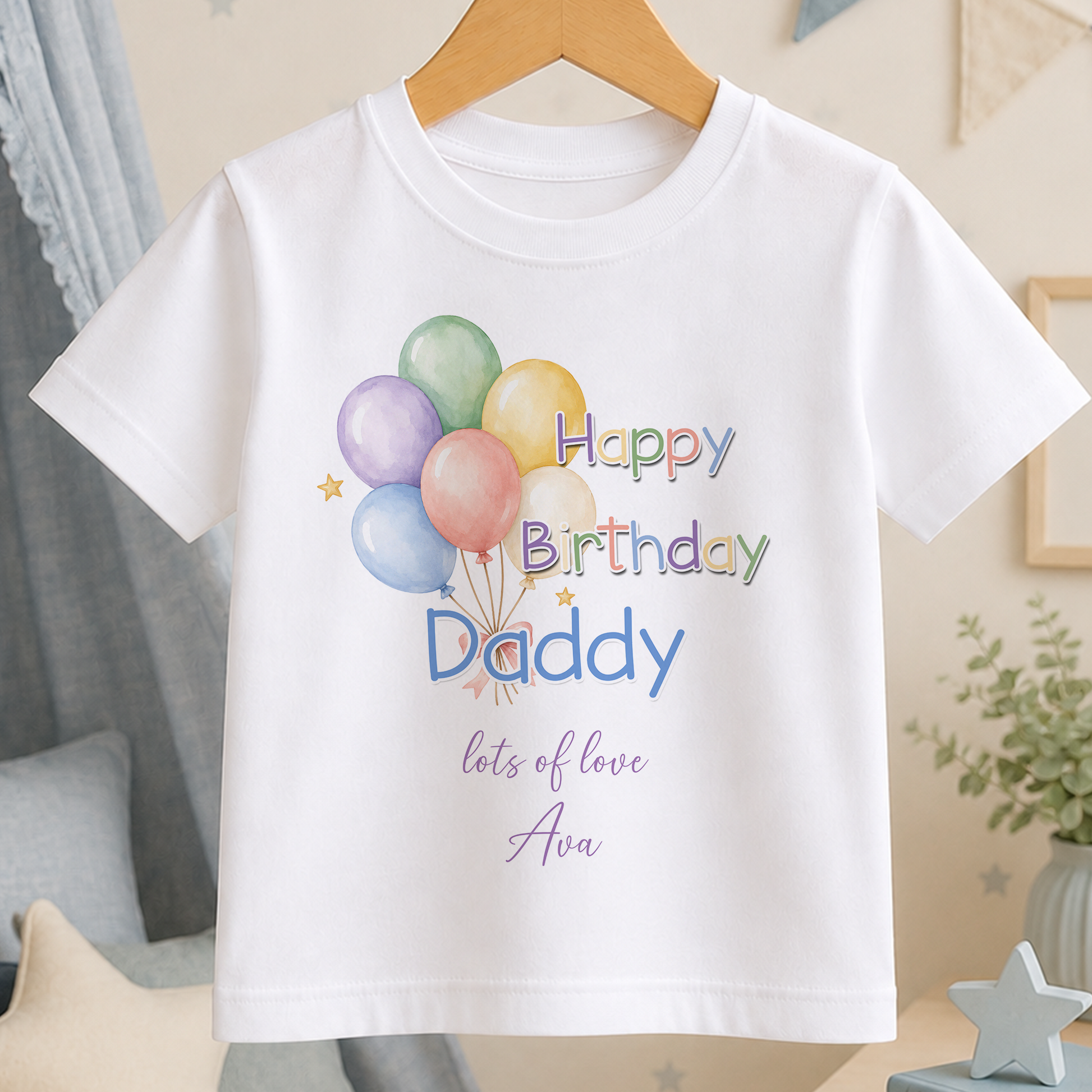A white t-shirt with a birthday message printed on it, featuring colorful balloons and the text "Happy Birthday Daddy" along with the phrase "lots of love Ava".