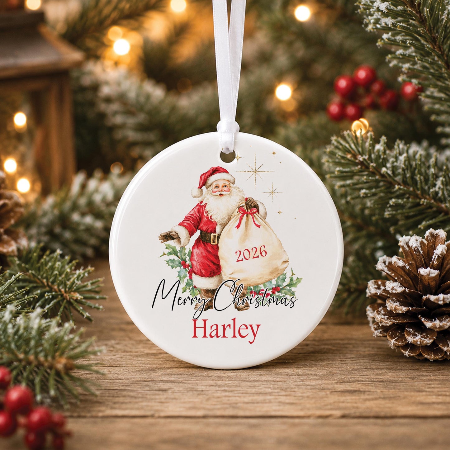 Personalised round ceramic Christmas bauble featuring a vintage watercolour Father Christmas holding a gift sack, festive holly, Merry Christmas wording, a name and year.