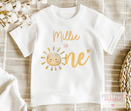 Sun is One personalised first birthday bib with a smiling sun and floral crown design.