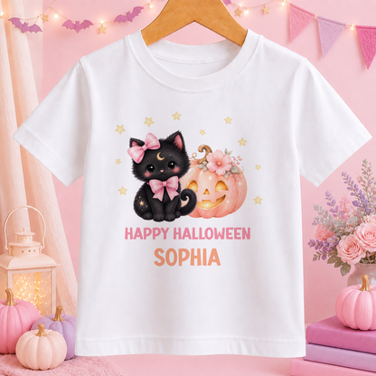 A white t-shirt with a Halloween-themed graphic design featuring a black cat, a pumpkin, and stars. The text on the t-shirt says "Happy Halloween Sophia".