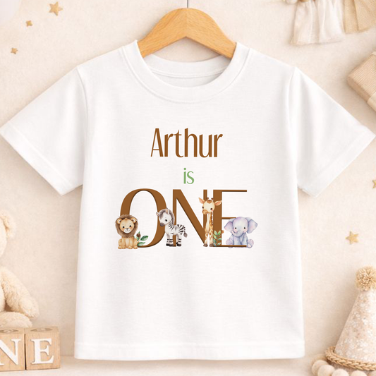 Personalised Safari Animals 'I Am One' first birthday t-shirt printed with a custom name, featuring a lion, zebra and elephant design.