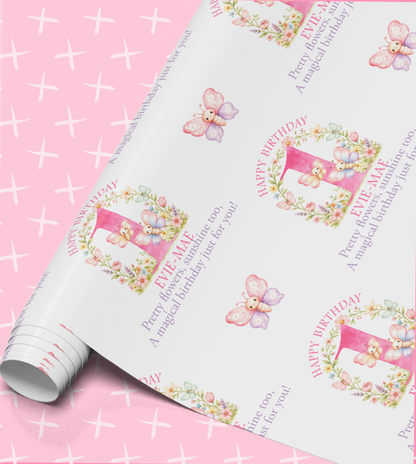a pink background with a roll of wrapping paper that has a repeating pattern of butterflies and flowers. The paper has a pink and white color scheme and includes text that reads "Happy Birthday" and "Eve ME".