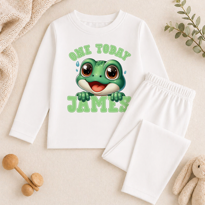 White long-sleeved personalised top with a frog print, paired with matching white bottoms and styled with birthday props.