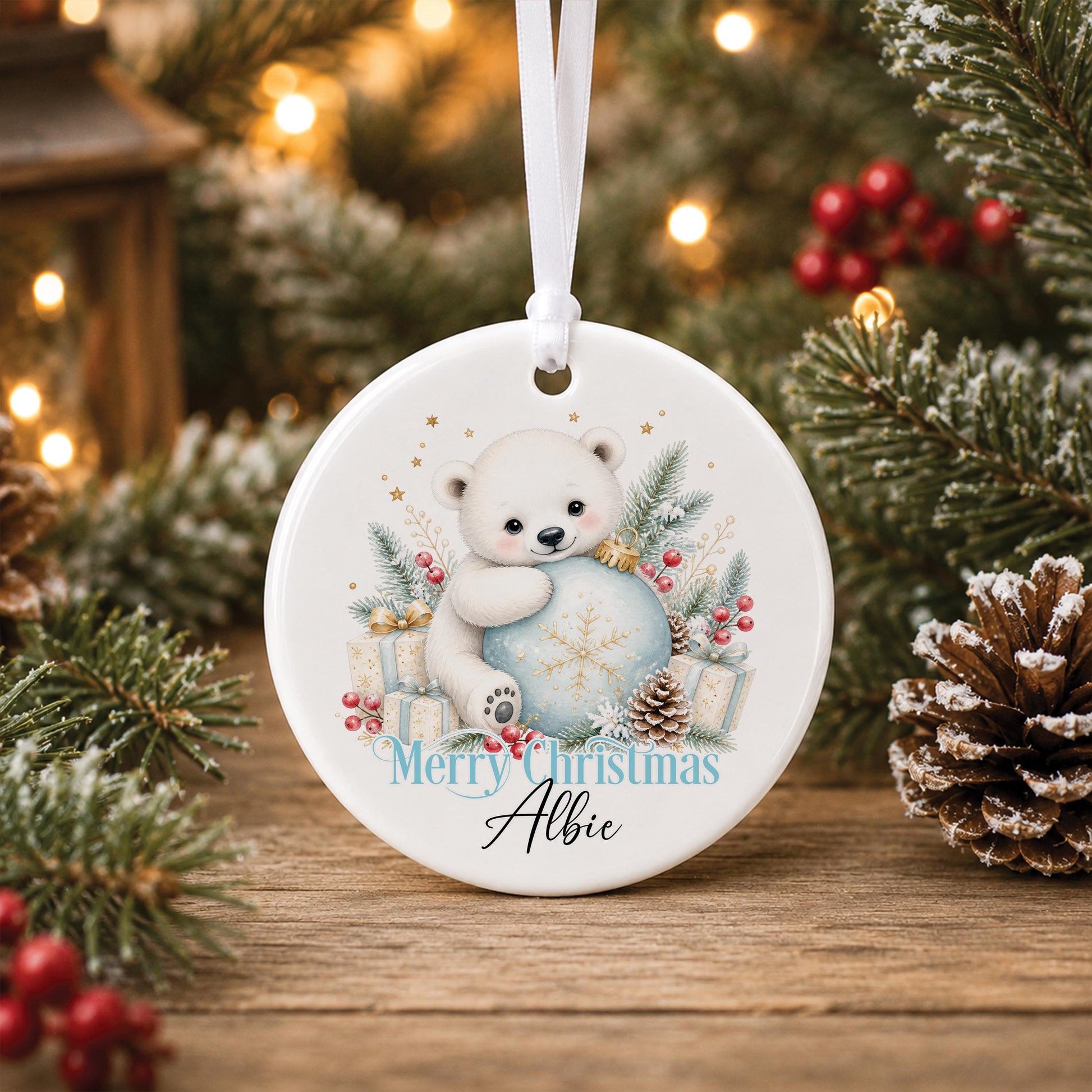 Personalised polar bear Christmas bauble, white ceramic ornament with a polar bear holding a blue snowflake, printed with Merry Christmas and a name