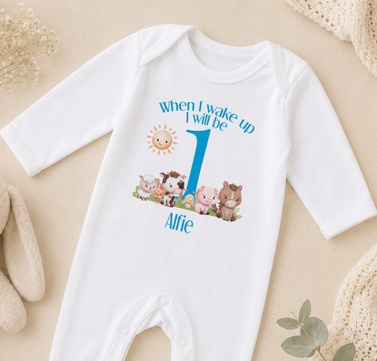A white onesie with a personalized message and cartoon animals printed on it, placed on a beige surface.