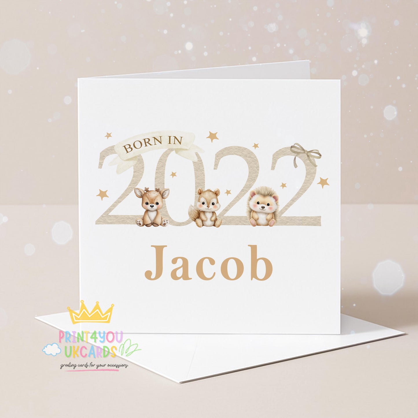 Square newborn baby card shown at an angle to display the beige woodland animal design and card stock.