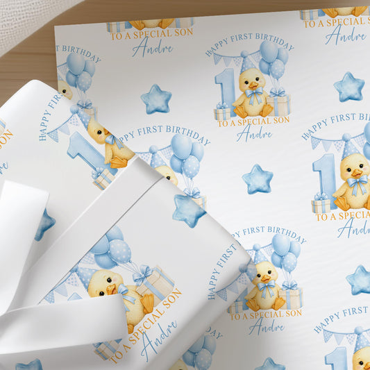 Close-up of personalised first birthday wrapping paper featuring a cute duckling, blue number one, balloons and presents on premium white wrapping paper.