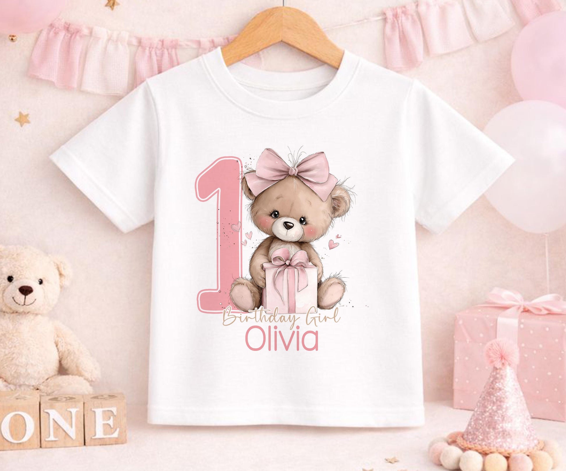 Personalised pink teddy bear first birthday outfit with the baby girl's name printed beneath the design.