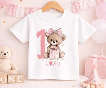 Personalised pink teddy bear first birthday outfit with the baby girl's name printed beneath the design.