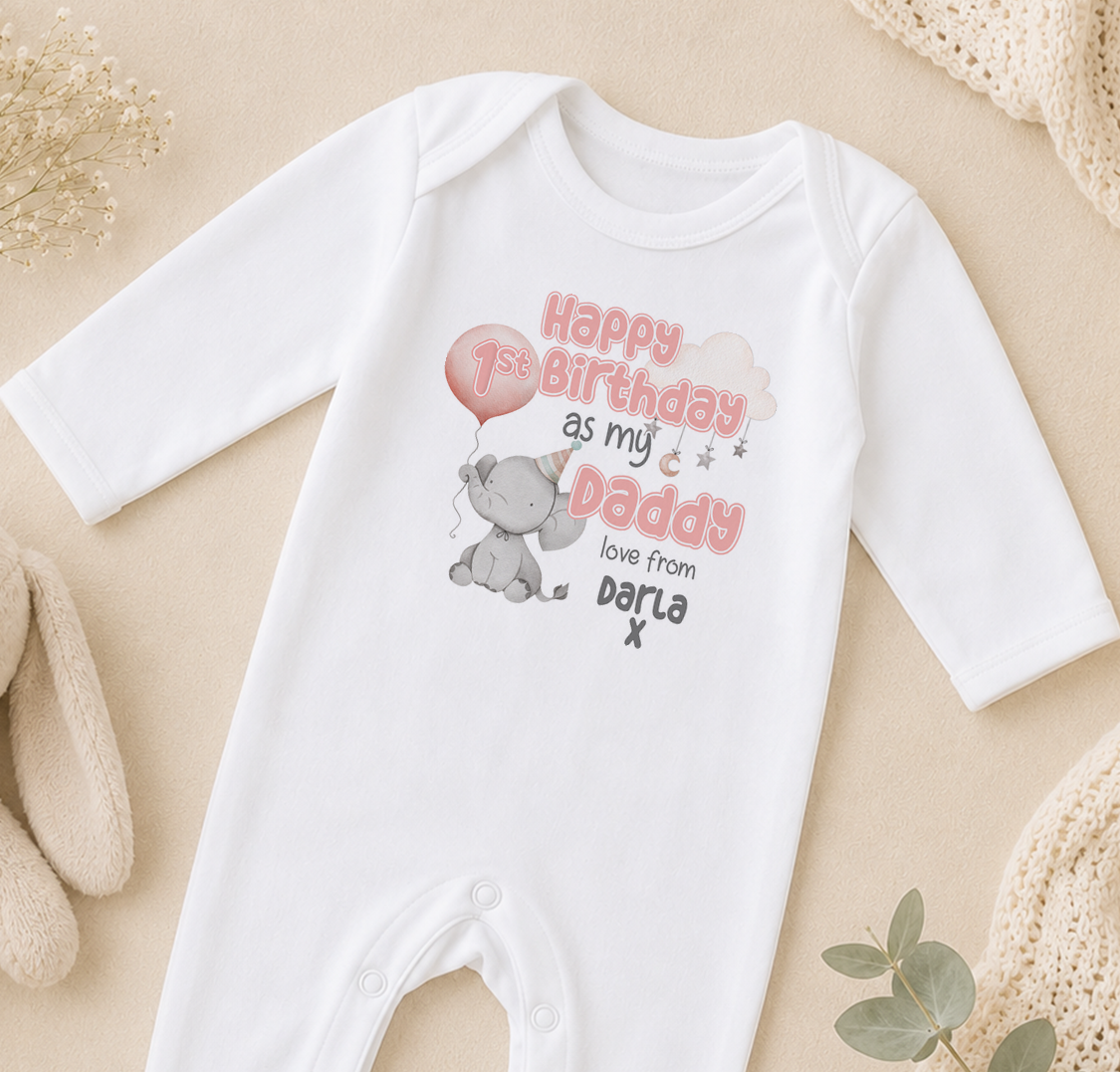 A white onesie with a birthday message printed on it, featuring an elephant and a balloon.