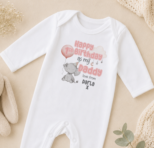 A white onesie with a birthday message printed on it, featuring an elephant and a balloon.