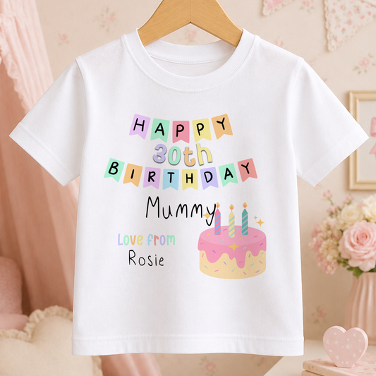 White kids' t-shirt printed with a colourful birthday cake and lit candles design, ready for a personalised name and age