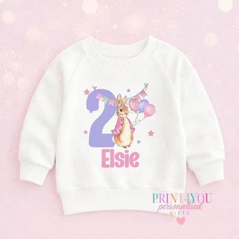 Children's white top with a personalised bunny 2nd birthday design, laid flat, front view
