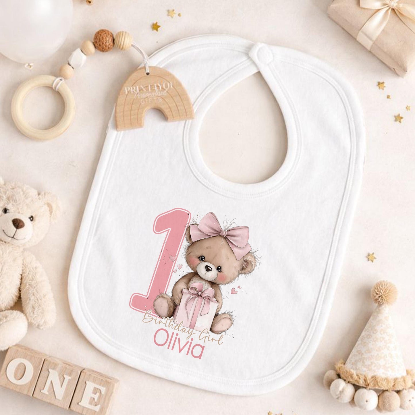 Pink teddy bear themed personalised first birthday outfit, styled with keepsake props for photos.