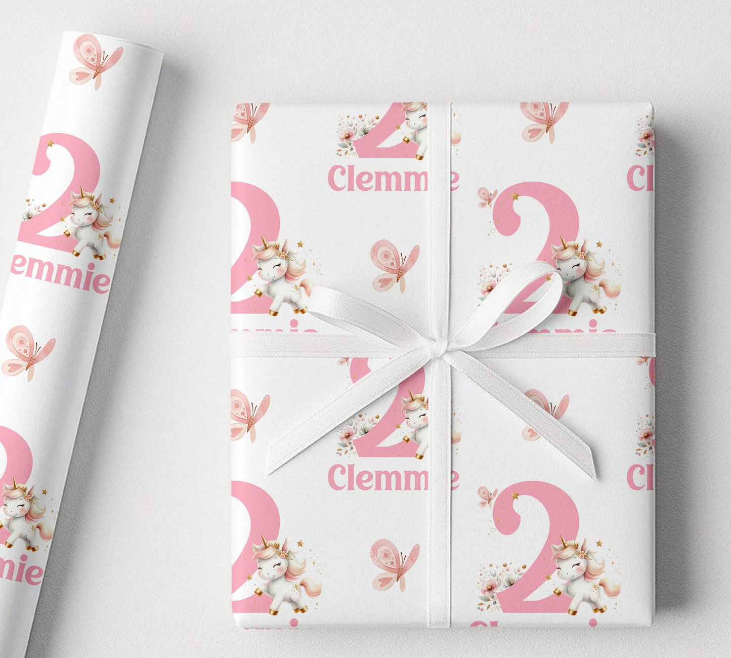A gift wrapped in personalised pink and white unicorn wrapping paper, finished with a white ribbon