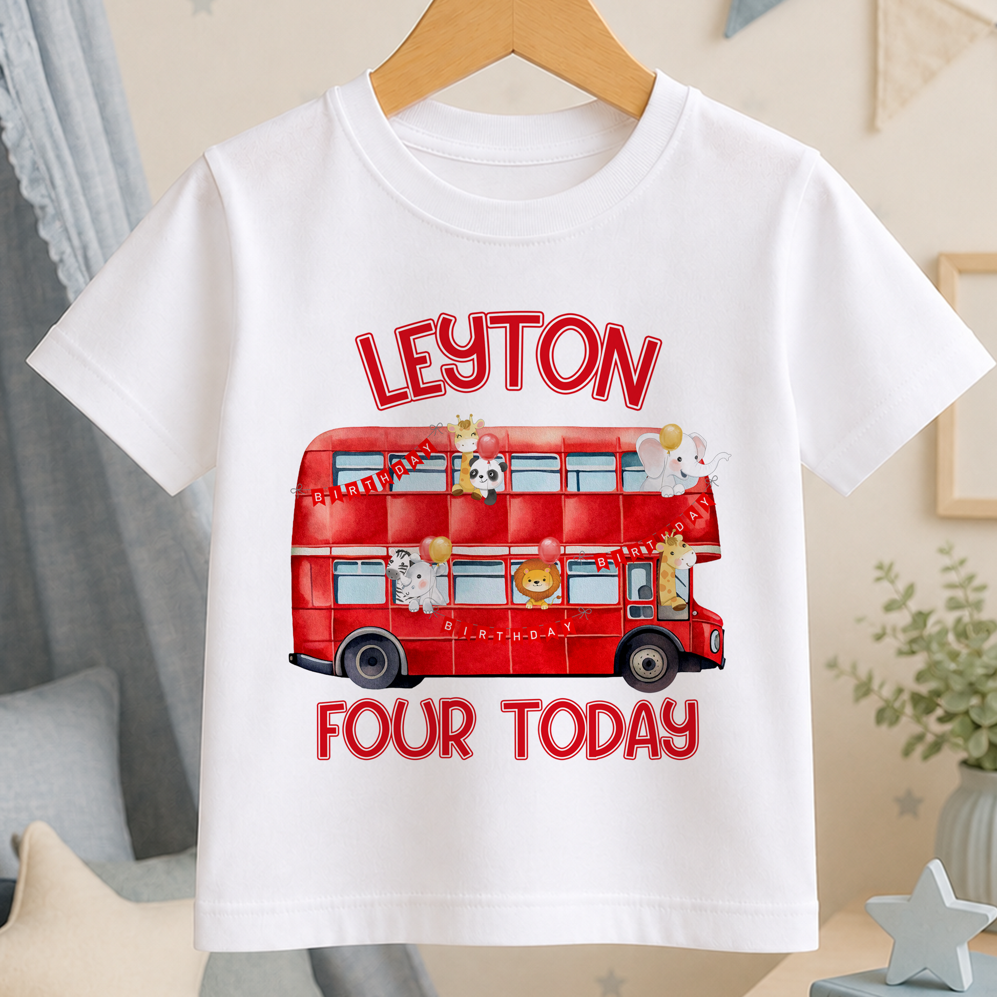 White cotton kids T-shirt printed with a red London double-decker bus carrying safari animal passengers, personalised with a Happy Birthday name design.