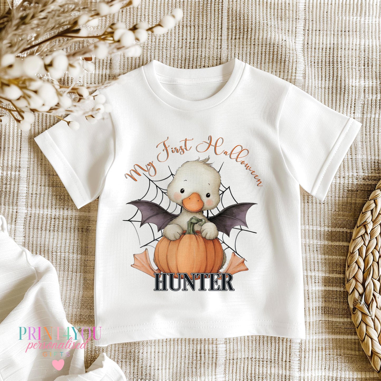 Close-up of the duck-in-pumpkin Halloween print showing the bat wing detail on a personalised baby vest