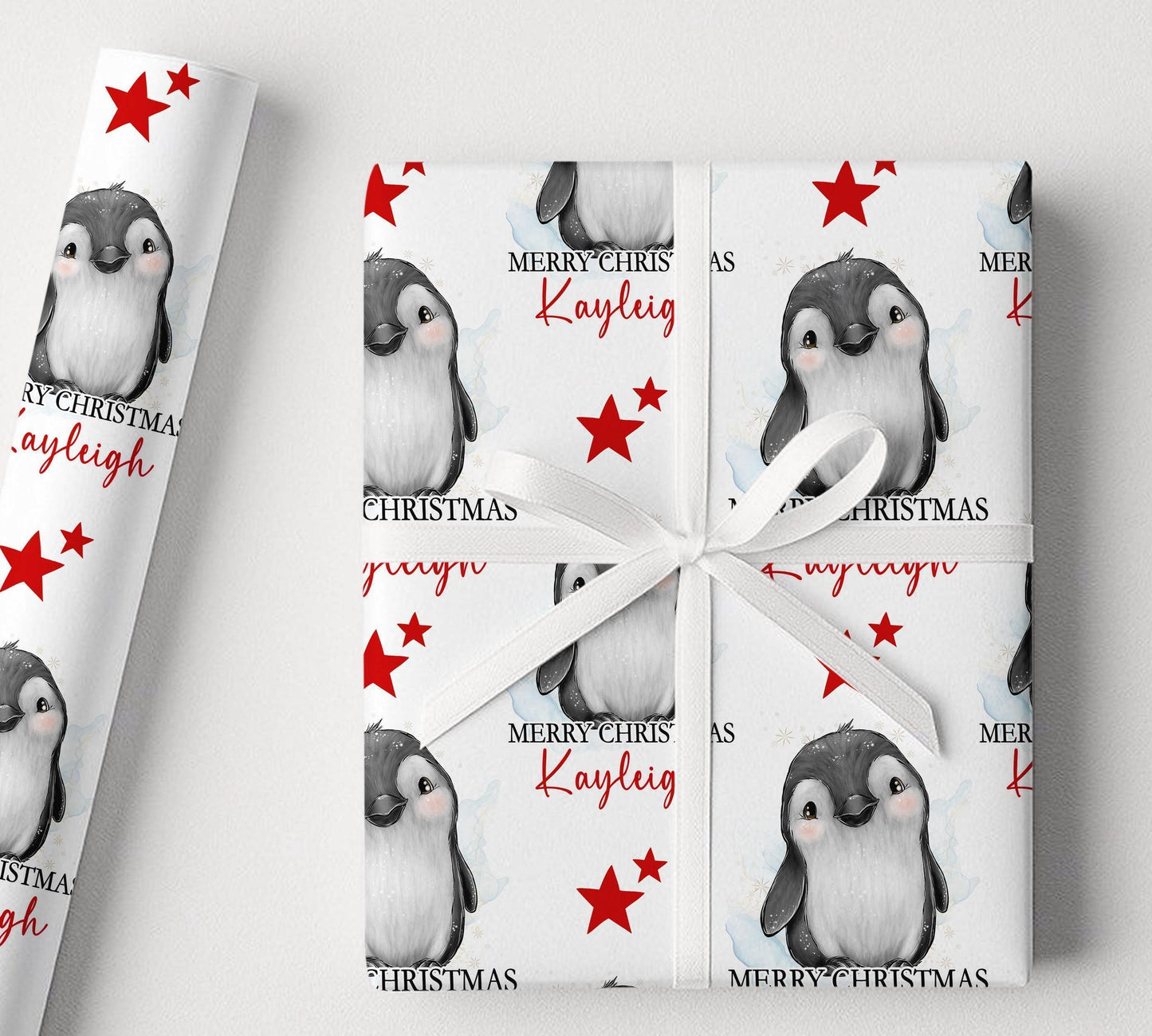 Personalised penguin Christmas wrapping paper example shown on a wrapped gift