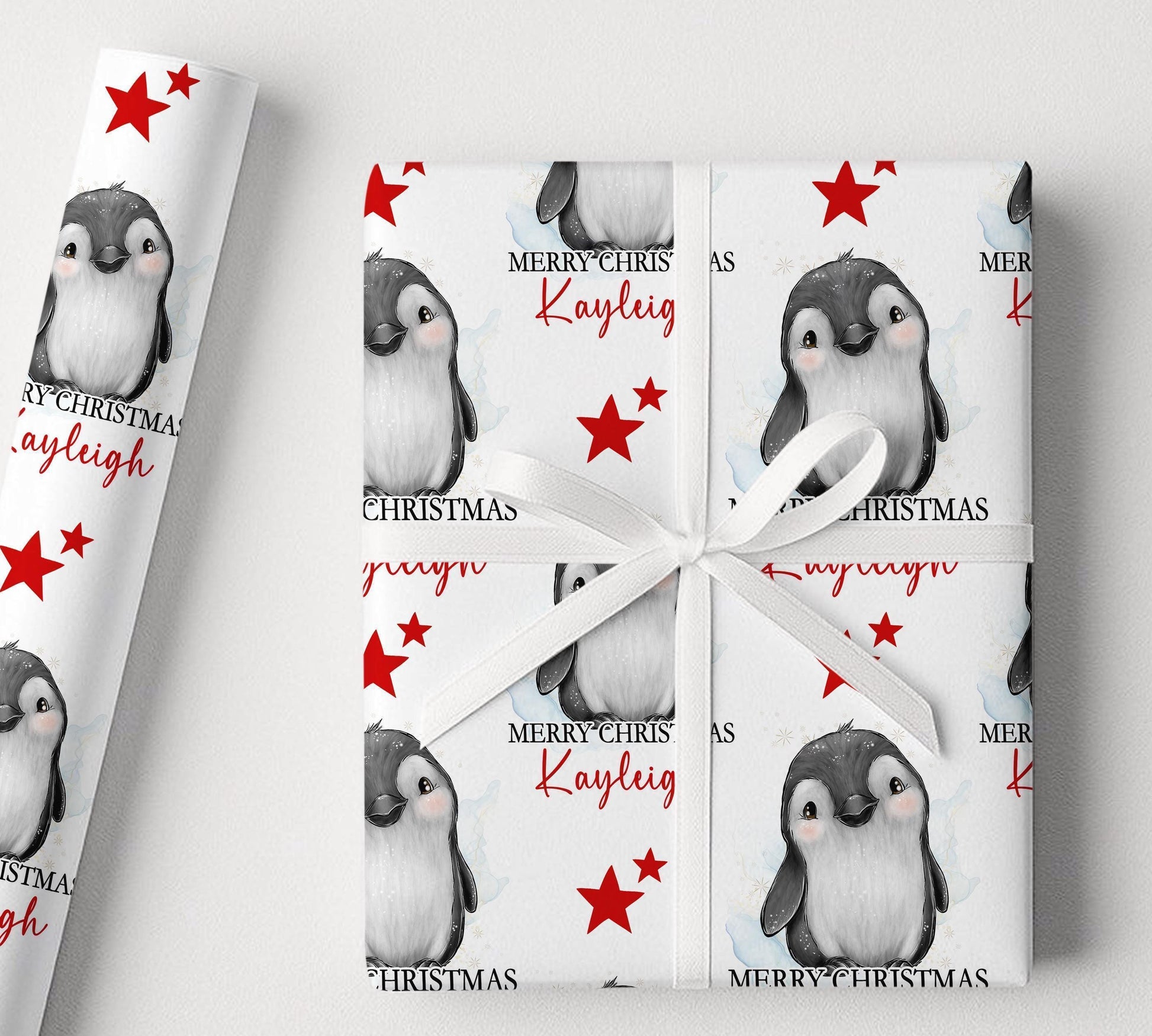 Personalised penguin Christmas wrapping paper example shown on a wrapped gift