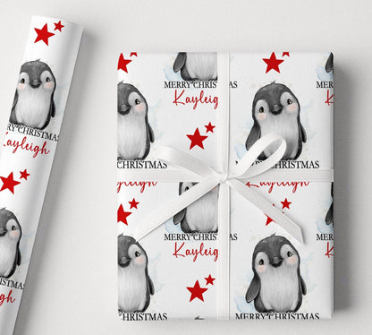 Personalised penguin Christmas wrapping paper example shown on a wrapped gift