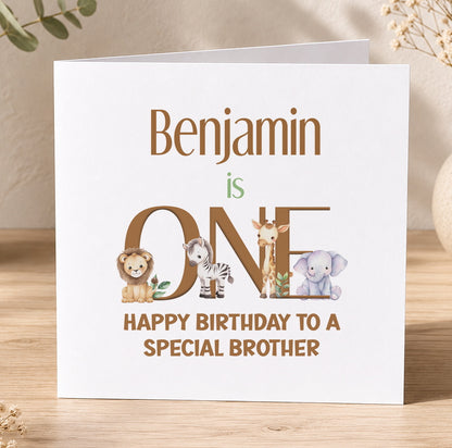 Square jungle-themed first birthday card for Benjamin, with the name spelled out using illustrated safari animals including a lion, zebra, giraffe and elephant, reading 'Happy Birthday to a special brother'.