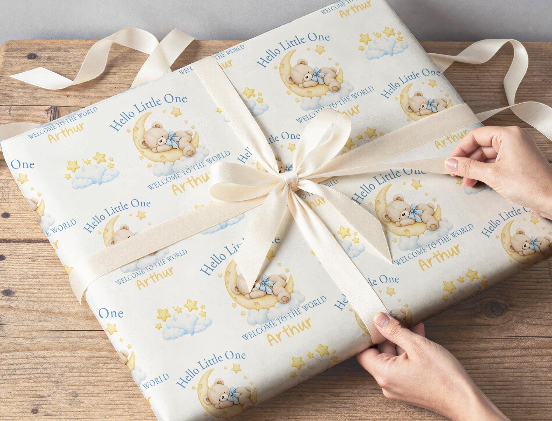 New baby gift wrapped in personalised Hello Little One teddy bear moon wrapping paper with custom name