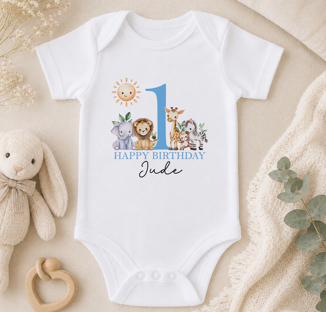 Personalised white baby vest printed with a blue number 1, a 'Happy Birthday' message and jungle animal illustrations.