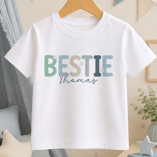 A white t-shirt with the name "BESTIE Thomas" printed on it in a stylized font.