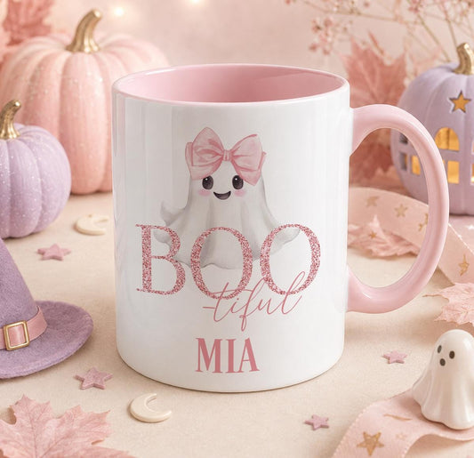 Personalised Halloween mug with a pink handle and inner, featuring a cute ghost wearing a pink bow and glitter-style Boo-tiful text, printed with the name Mia