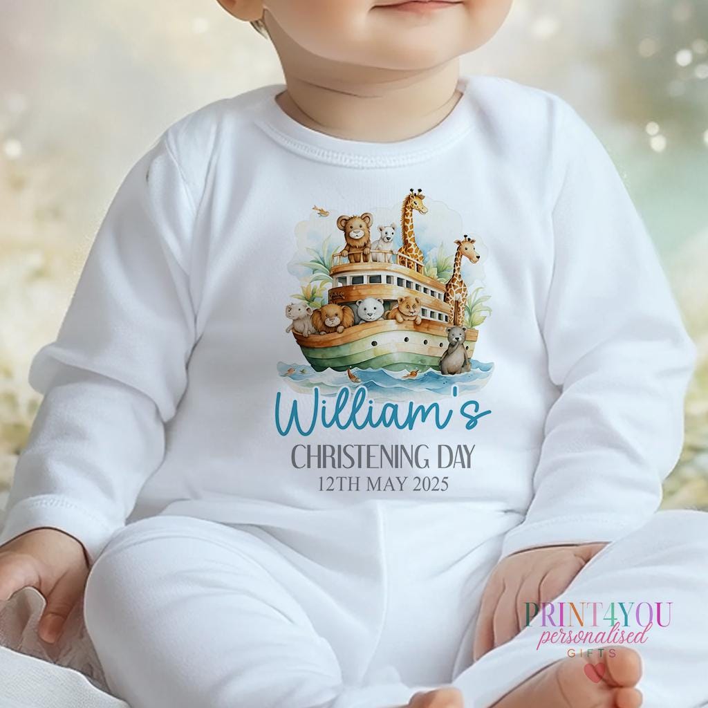 Personalised Noah's Ark christening outfit flat lay, customised with baby's name and date.