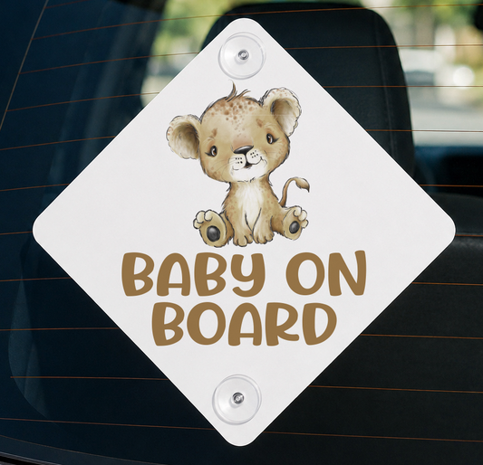 White diamond-shaped aluminium car window sign reading 'Baby on Board' with an illustrated baby lion cub