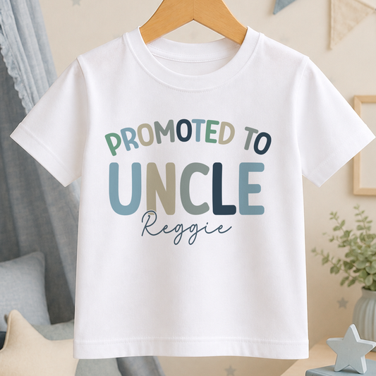 A white t-shirt with the text "PROMOTED TO UNCLE Reggie" printed on it.