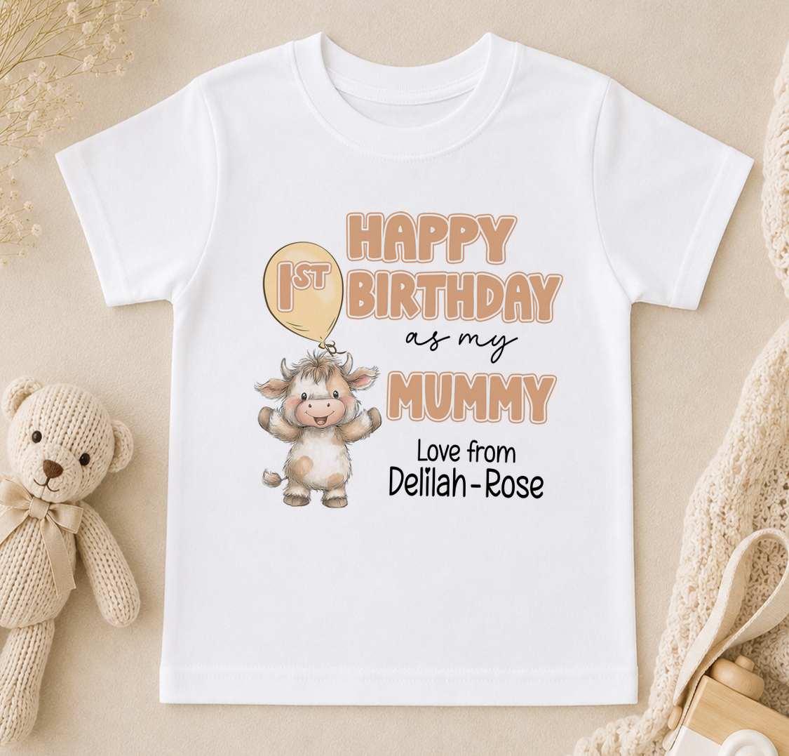 A white t-shirt with a birthday message for a baby, featuring a cartoon cow and the text "Happy 1st Birthday as my Mummy Love from Delilah - Rose".