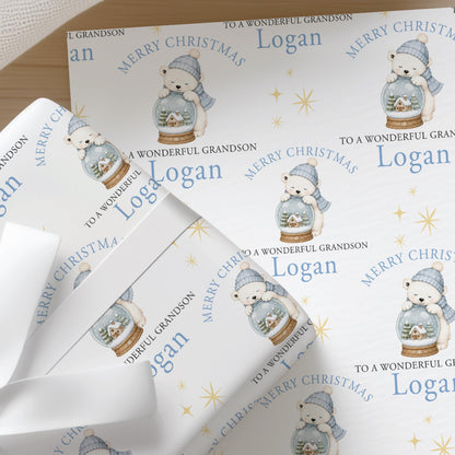 Personalised Christmas wrapping paper featuring a polar bear inside a snow globe, with a custom name printed across the design.