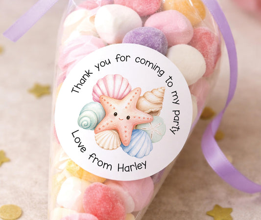 Personalised glossy round sticker featuring a starfish beach party design with a child's name