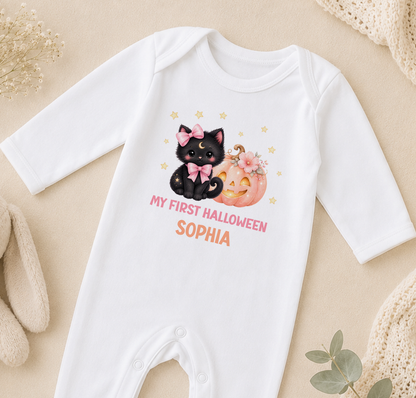 A white onesie with a black cat and a pumpkin graphic, along with the text "My first Halloween Sophia" printed on it.