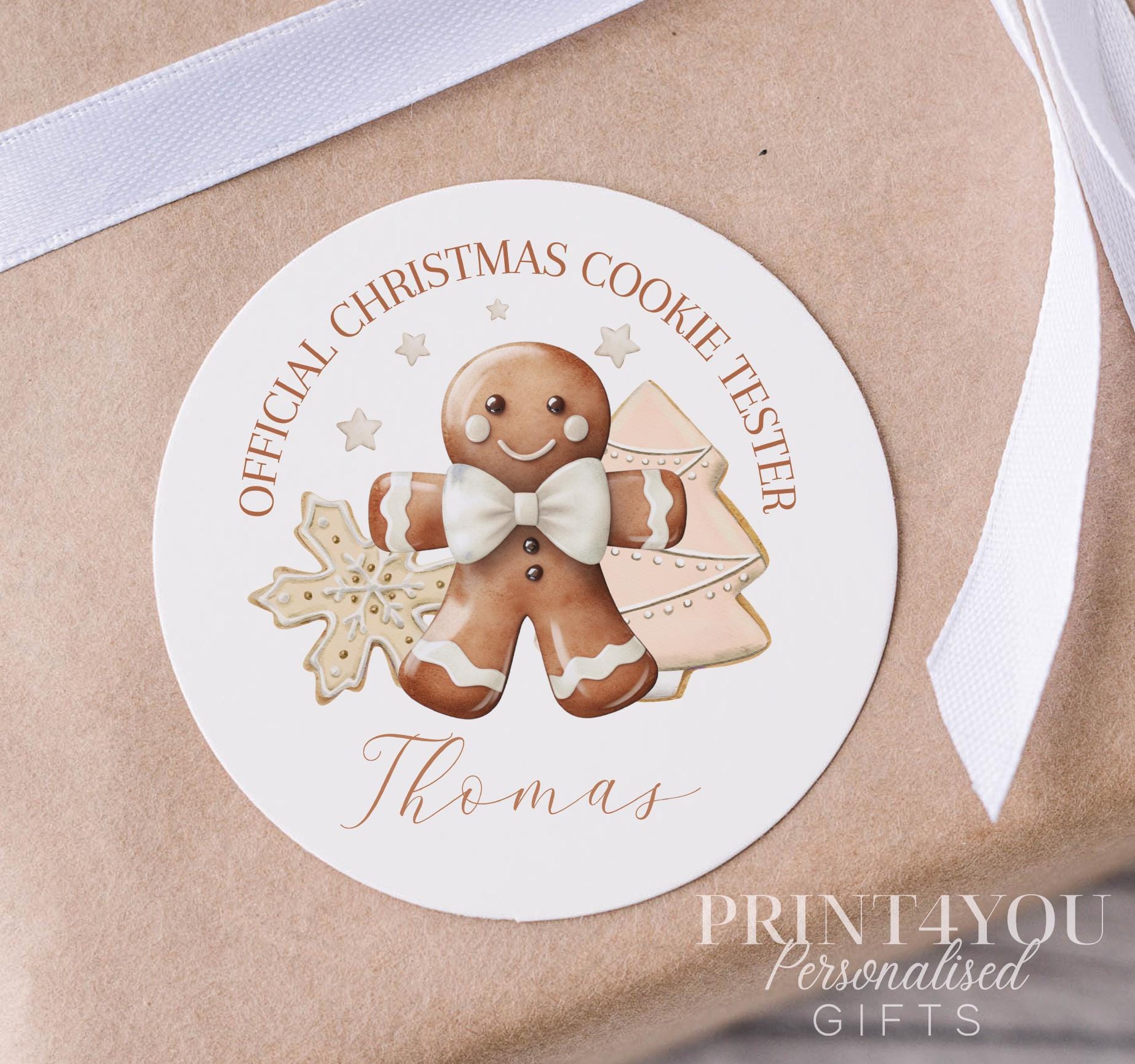 Personalised glossy white round Christmas gift label sticker with a custom name, shown as a pack of stickers on a strip, 5cm each