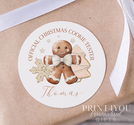 Personalised glossy white round Christmas gift label sticker with a custom name, shown as a pack of stickers on a strip, 5cm each
